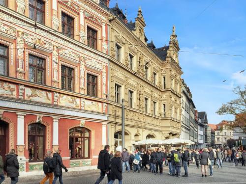 エアフルトにあるCozy apartment in the heart of Erfurt 30 m² city viewの建物前を歩く人々