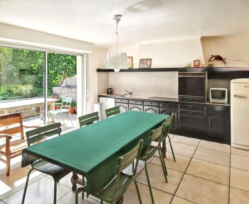 une cuisine avec une table et des chaises vertes dans l'établissement Maison pittoresque à Camaret sur Mer avec vue sur mer, à Camaret-sur-Mer