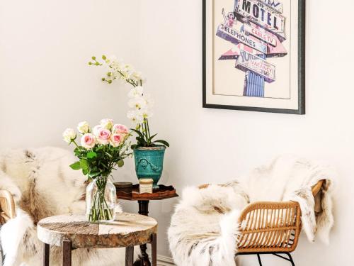 a living room with a couch and a table with flowers at Spring House by The Suffolk Cottage Collection in Aldeburgh