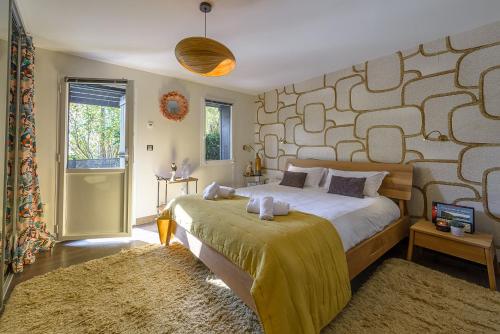 a bedroom with a large bed and a wall with at Cottage Flottant - Vue Lac in Veyrier-du-Lac
