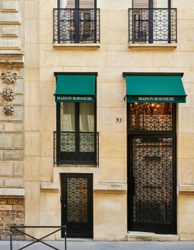 a building with two green awnings and two doors at Maison Boissière BARNES Residences in Paris