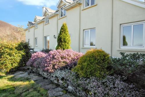 a house with flowers in front of it at Spacious house with sea and mountain views, Co. Kerry in Kells