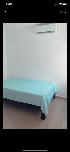a bed with a blue sheet on top of it at Carla alojamiento in Tapachula