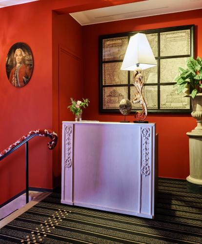 a room with red walls and a table with a lamp at Maison Boissière BARNES Residences in Paris