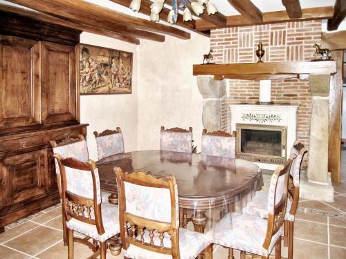 une salle à manger avec une table et une cheminée dans l'établissement Maison charmante à Chéronvilliers, à Chéronvilliers