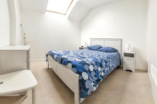 une chambre avec un lit dans une pièce blanche dans l'établissement Maison accueillante à Monthenault avec jardin privé, à Monthenault