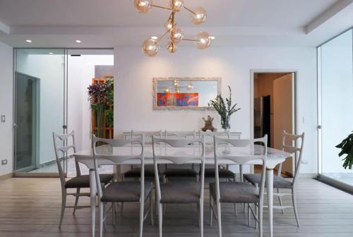 a dining room with a white table and chairs at Casa Junin by Wynwood House in Lima