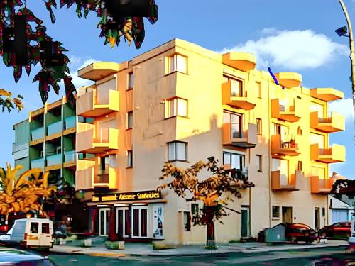 un bâtiment jaune avec des fenêtres donnant sur une rue de la ville dans l'établissement Appartement charmant à Saint-Cyprien avec vue sur la mer - 24m², à Saint-Cyprien