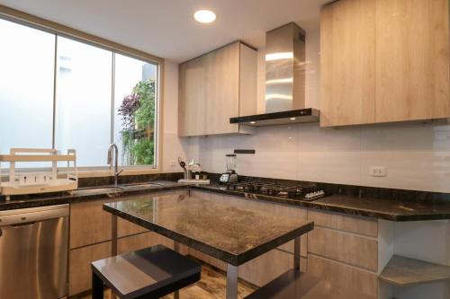 a kitchen with a large island in the middle at Casa Junin by Wynwood House in Lima
