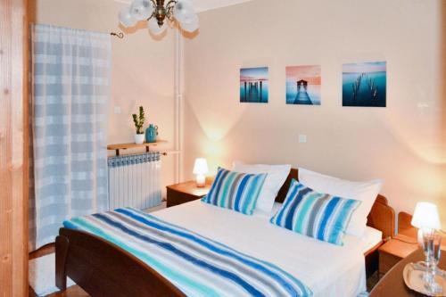 een slaapkamer met een bed met blauwe en witte kussens bij Spacious Apartment in Klis + Balcony in Klis