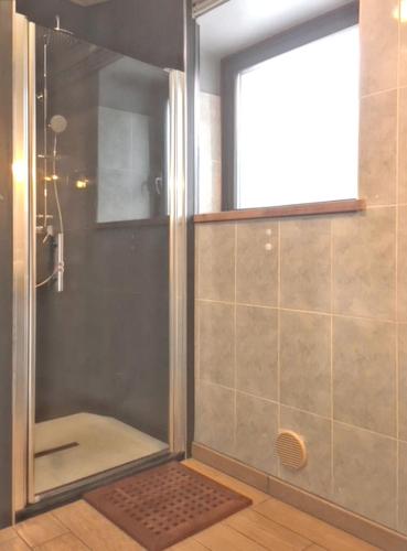 une douche avec une porte vitrée dans une salle de bain dans l'établissement Maison cosy à Cauterets avec vue sur les montagnes et jardin, à Cauterets