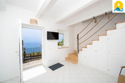 a white hallway with stairs and a view of the ocean at Casa Angelie in Praiano