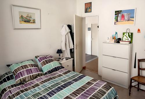 a bedroom with a bed and a dresser and a mirror at Villa charmante à Soulac-sur-Mer avec piscine privée in Soulac-sur-Mer