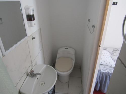 a small bathroom with a toilet and a sink at Hospedaje snack bar titanic in Ica