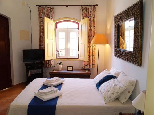 a bedroom with a bed with two towels on it at Rustic Village House for Nature & Trekking Lovers in Furnazinhas