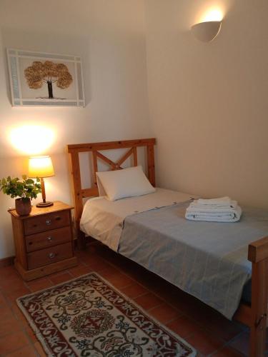 a bedroom with a bed and a table with a lamp at Rustic Village House for Nature & Trekking Lovers in Furnazinhas
