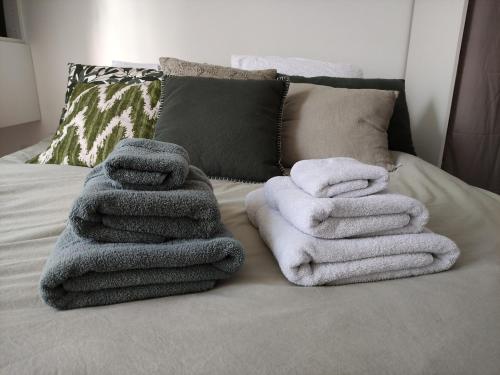 une pile de serviettes posée sur un lit dans l'établissement Angers appart 65m2 proche centre ville, parking, à Angers