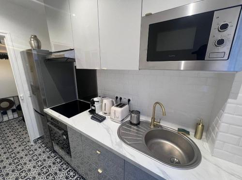 a kitchen with a sink and a microwave at Très bel appartement proche Disney Paris in Les Pavillons-sous-Bois