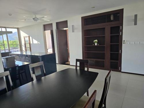 a dining room with a black table and chairs at casuarina shores penthouse in Bang Tao Beach