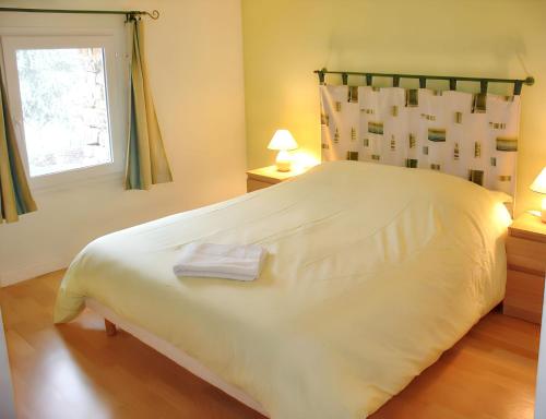 a large white bed in a bedroom with a window at Maison de charme avec piscine et jardin à Saint-Vincent-la-Châtre in Saint-Vincent-la-Châtre