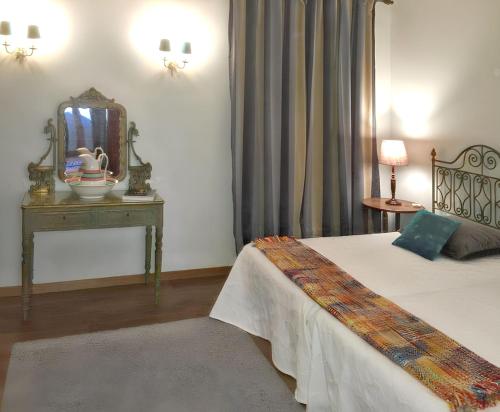 a bedroom with a bed with a mirror and a table at Family House with Mountain View in Vouzela in Vouzela