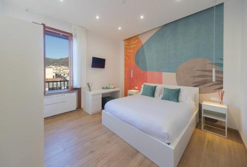 a bedroom with a bed and a large painting on the wall at City Rooms 74 in Salerno