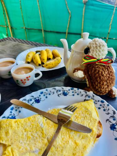 a table with a plate of omelet and a plate of food at Marari Red Angel in Mararikulam