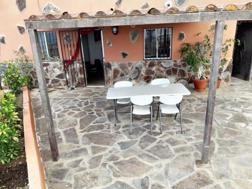 a stone patio with a white table and chairs at House with view and jacuzzi in Adeje in Adeje