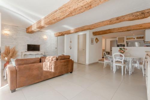 un salon avec un canapé marron et une table dans l'établissement Maison Sainte Maxime, à Le Plan
