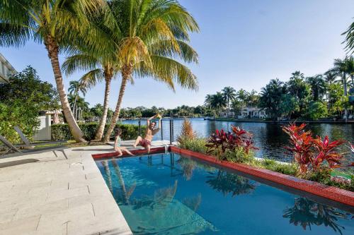 two girls are doing yoga on the edge of a swimming pool at VILLA ST-BARTH Waterfront w htd pool by VIAC in Fort Lauderdale