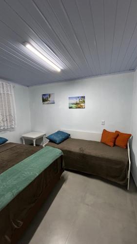 a room with two beds and a table in it at Pousada Erdmann in São Gabriel