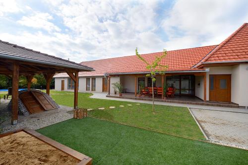 a house with a yard with a lawn sidx sidx sidx sidx at Virág Vendégház in Hercegkút