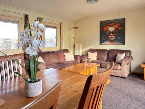 a living room with a table and a couch at VISSERSLUST Rooms, Apartments and Houseboats in Vinkeveen