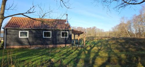 une vieille maison située sur une colline herbeuse dans l'établissement The Kottage, à Oostkapelle