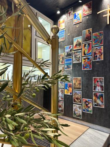 a wall with posters on it with a plant at Colombia Apartments&Rooms in Durrës