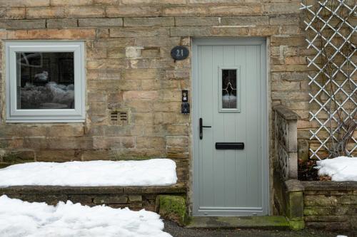 a stone house with a door and two windows at The little cottage in Queensbury