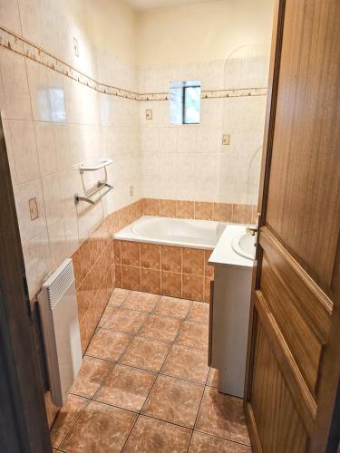 une salle de bain avec une baignoire et un lavabo dans l'établissement Maison conviviale à Peyrusse le Roc, avec jardin sans vis-à-vis, à Peyrusse-le-Roc