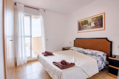 sypialnia z łóżkiem i oknem w obiekcie Seaside Apartment in Mojácar + Pool w mieście Mojácar