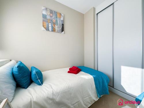 a bedroom with a bed with blue and red pillows at Brisa Azul in Cabanes