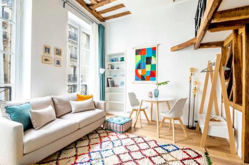 un salon avec un canapé et une table dans l'établissement Stylish Parisian Flat in the Marais - SAINT-PAUL, à Paris
