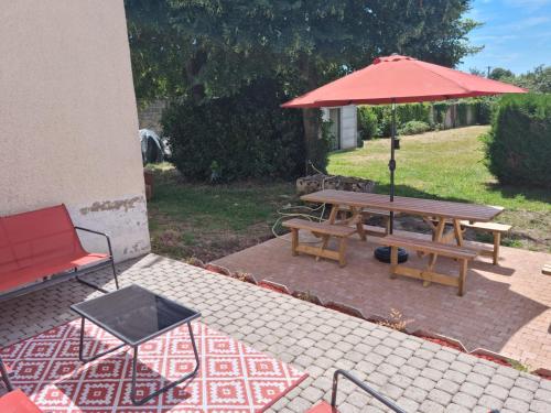 a picnic table and an umbrella on a patio at Gîte les 2 cygnes à Briare dans le Loiret in Briare