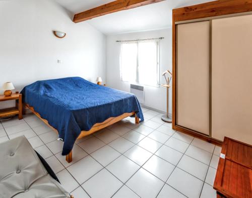 a bedroom with a blue bed and a chair at Charmante maison à Argelès-sur-Mer avec vue sur montagne in Argelès-sur-Mer