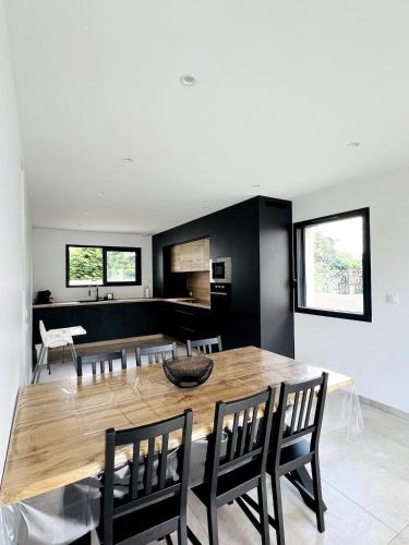 une cuisine et une salle à manger avec une table et des chaises en bois dans l'établissement Maison Familiale du Canal, à Boisset-lès-Montrond