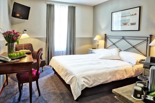 Cette chambre comprend un lit et un bureau. dans l'établissement Hotel Montana Zürich, à Zurich