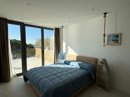 a bedroom with a blue bed and a large window at Seaside Resort in Trieste