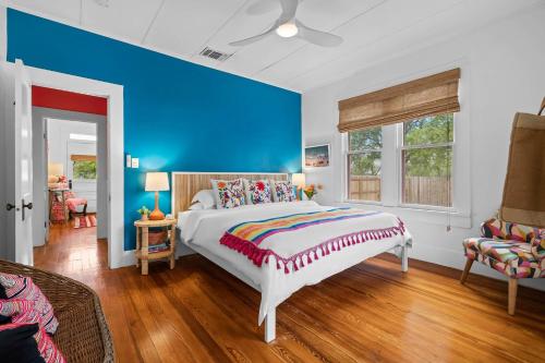 une chambre avec un lit et un mur bleu dans l'établissement Pink Duchess - Mins to Main Hot Tub & Fire Pit, à Fredericksburg