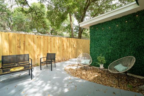 a patio with two chairs and a table and a fence at Cozy 1 Bedroom Duplex in Central Tampa in Tampa