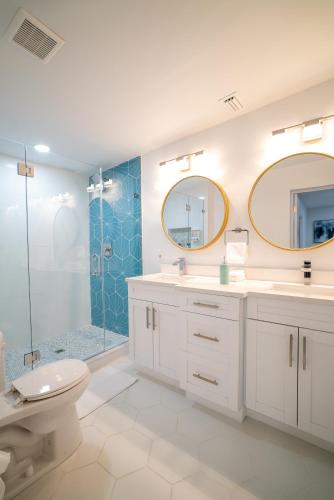 a bathroom with a toilet and two sinks and a shower at Cozy 1 Bedroom Duplex in Central Tampa in Tampa