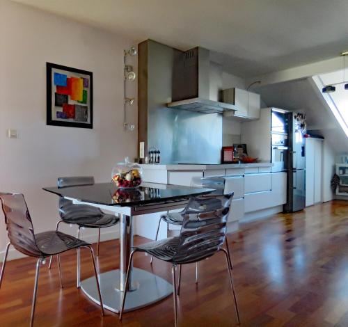 une cuisine avec une table et des chaises dans une pièce dans l'établissement L'OASIS - Loft standing - Terrasse Rooftop - Jacuzzi Spa - Parking, à Bayonne