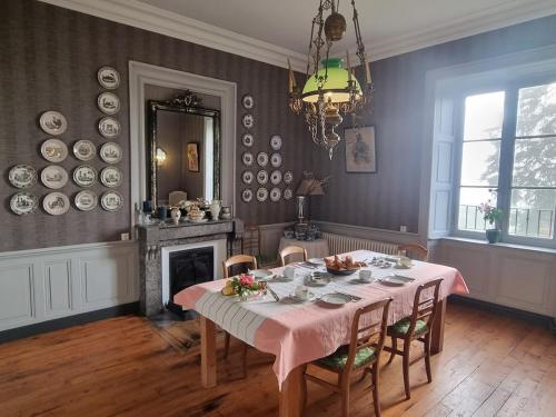 une salle à manger avec une table et un lustre dans l'établissement Le Rézinet - Gîte de groupes, à Pralong
